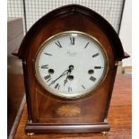 A mahogany mantle clock, of pointed form, inlaid with an oval fan,