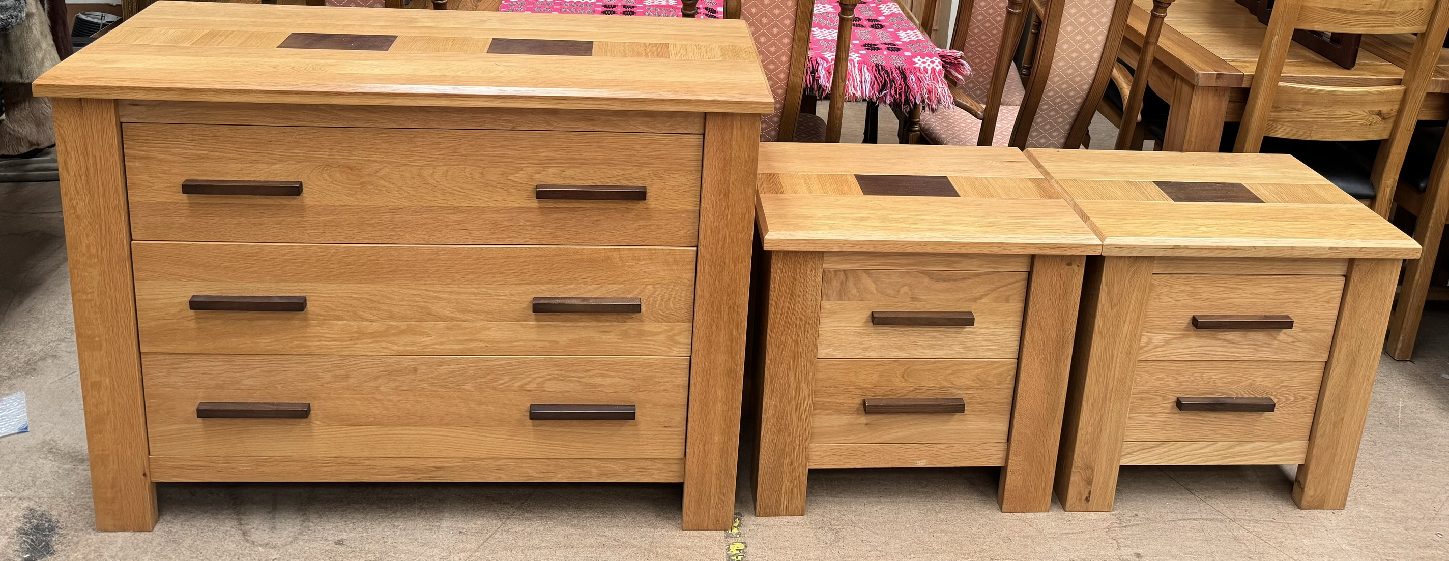 A modern oak chest with three long drawers together with a pair of matching bedside chests