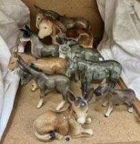 A Beswick donkey together with a collection of pottery donkey figures