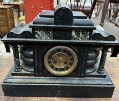 A black slate mantle clock of architectural form with Roman numerals