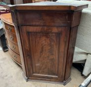 A 19th century mahogany hanging corner cupboard with an inverted breakfront top above a single