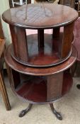 A 20th century mahogany revolving bookcase with two tiers on four leaf capped legs and claw and