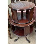 A 20th century mahogany revolving bookcase with two tiers on four leaf capped legs and claw and