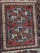 A rug with a red ground and two blue ground medallions decorated with stylised flowerheads and