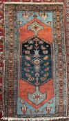 A rug with a central blue medallion with stylised flowerheads,