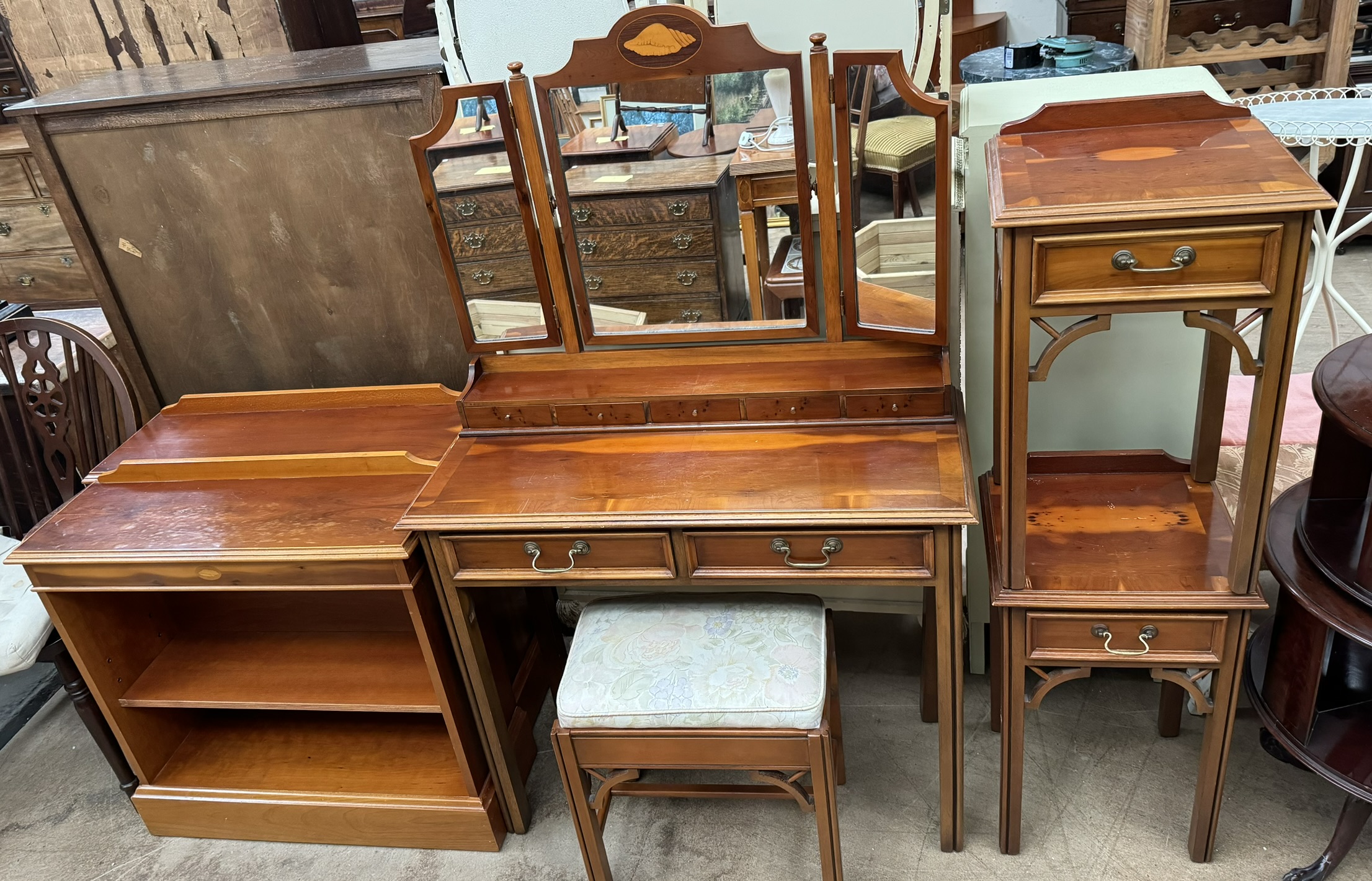 A modern yew dressing table together with a pair of yew bedside cabinets,