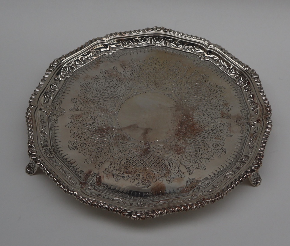 An Edwardian silver salver with a gadrooned edge, on three feet, London, 1902,