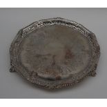 An Edwardian silver salver with a gadrooned edge, on three feet, London, 1902,