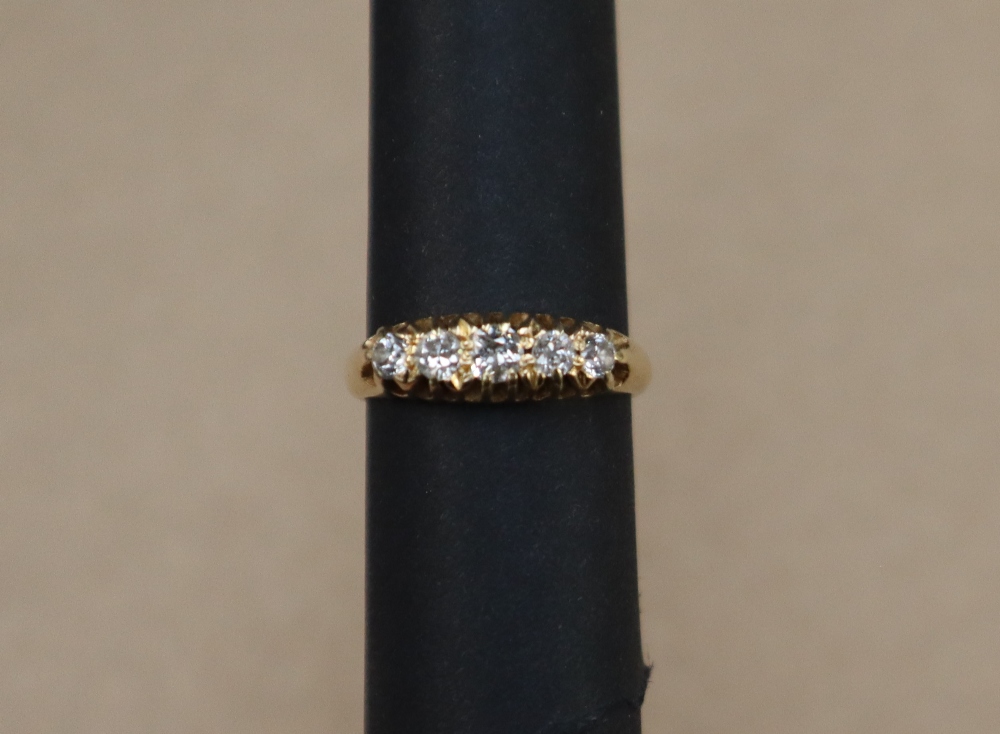 An 18ct yellow gold ring set with five graduated old cut diamonds, size K, approximately 3.