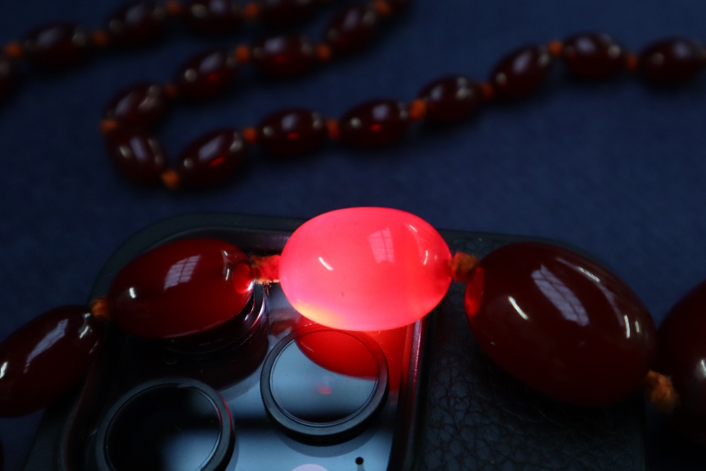A cherry amber / bakelite beaded necklace, with graduating beads varying in size from 30mm to 10mm, - Image 9 of 9