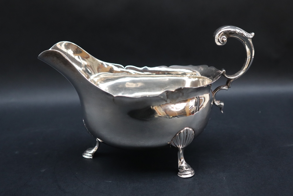 A Victorian silver sauce boat with a flared rim and scrolling handle on three shell capped legs and - Bild 3 aus 4