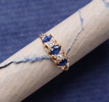 A sapphire and diamond ring set with three oval faceted sapphires and two round old cut diamonds to