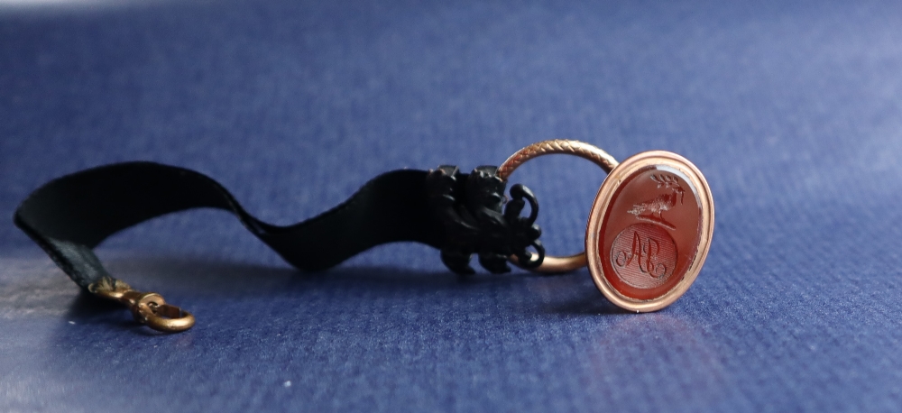 A hardstone intaglio fob seal of oval form with a bird holding a sprig above initials AP,