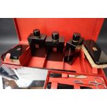 S T Dupont, a red leather travelling case fitted with two brushes, three bottles, easel mirror,