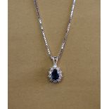 A sapphire and diamond cluster pendant, set with a pear shaped sapphire approximately 0.