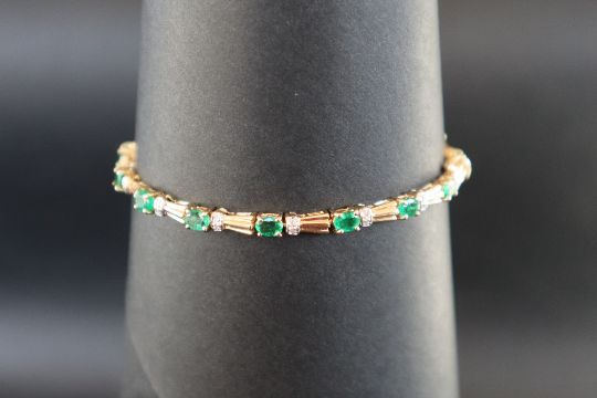 An emerald and diamond tennis bracelet set with sixteen oval faceted emeralds and diamonds to a - Image 2 of 6