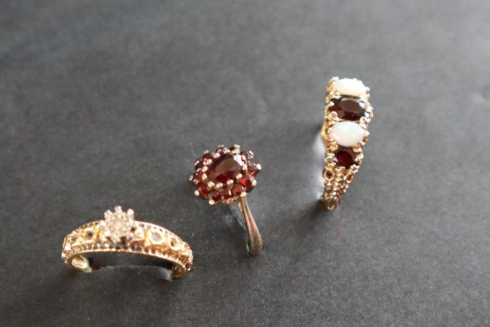A 9ct gold dress ring set with a line of three garnets and two opals, size P 1/2, - Image 2 of 8