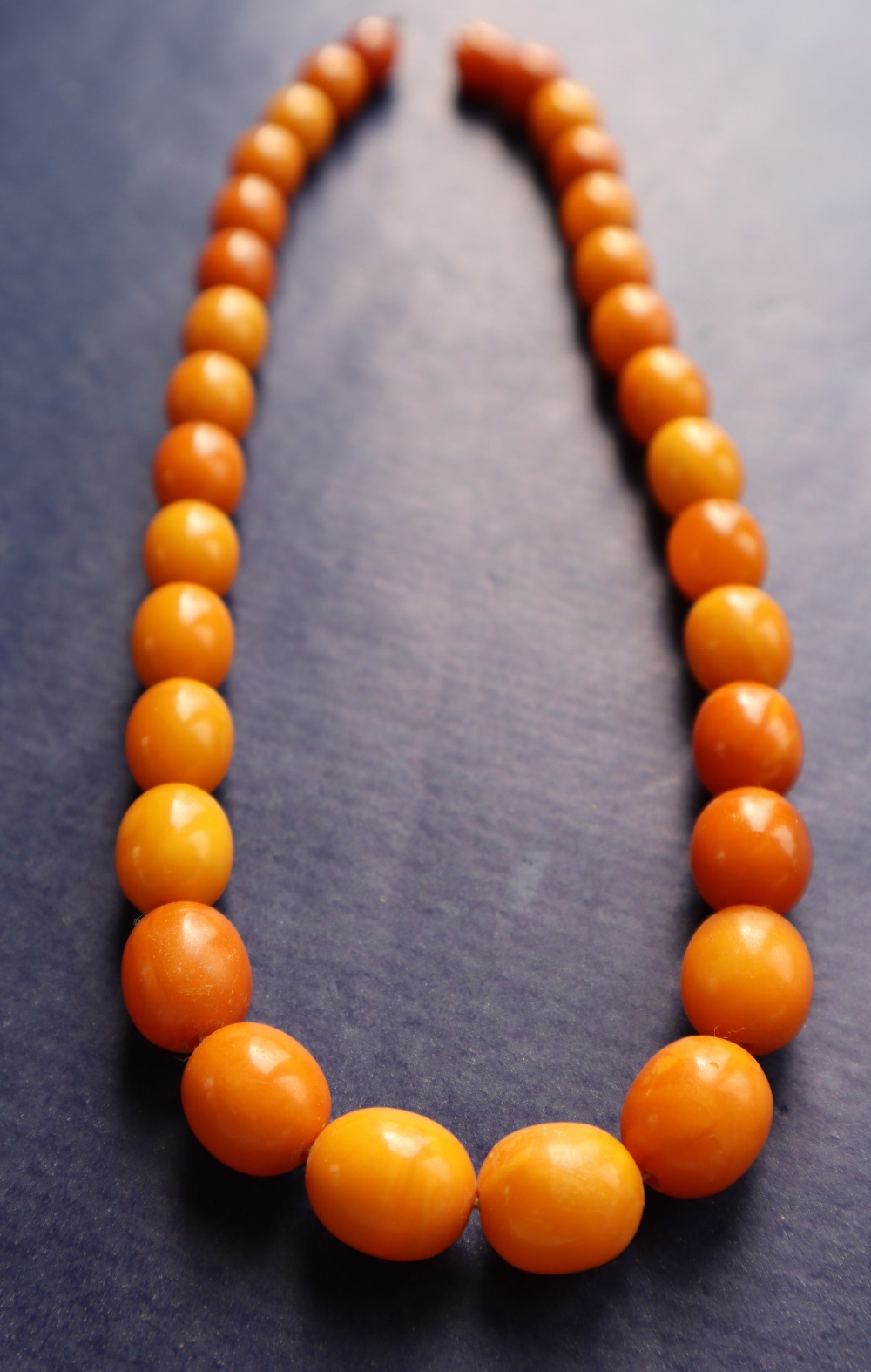 An amber bead necklace with graduated oval beads varying in size from 15mm to 10mm, 42cm long, - Bild 2 aus 4