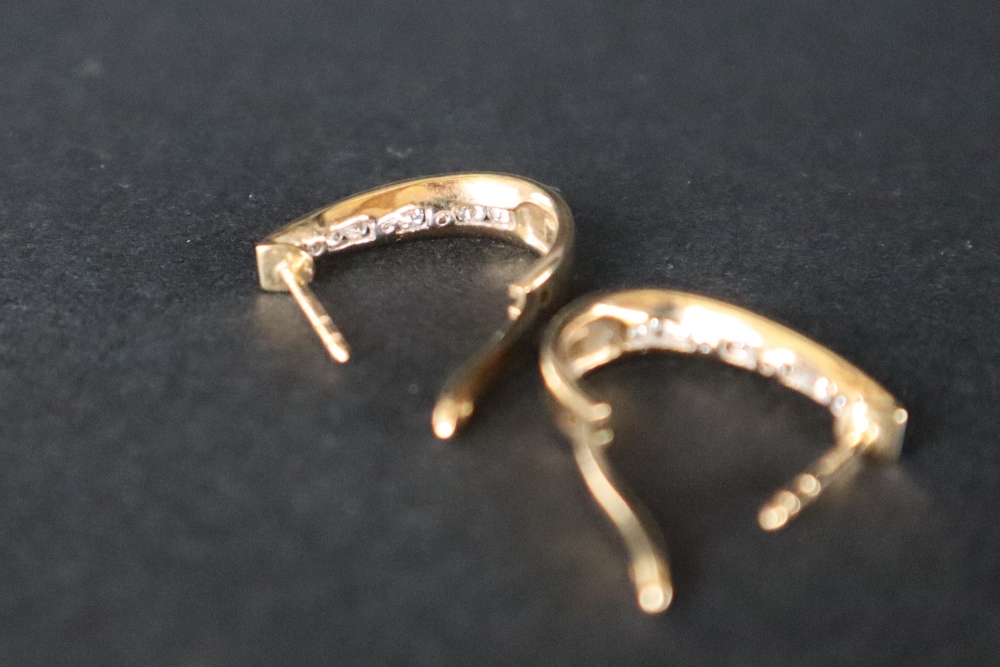 A pair of 14ct gold diamond set hoop earrings, with nine round brilliant cut diamonds, channel set, - Image 5 of 5