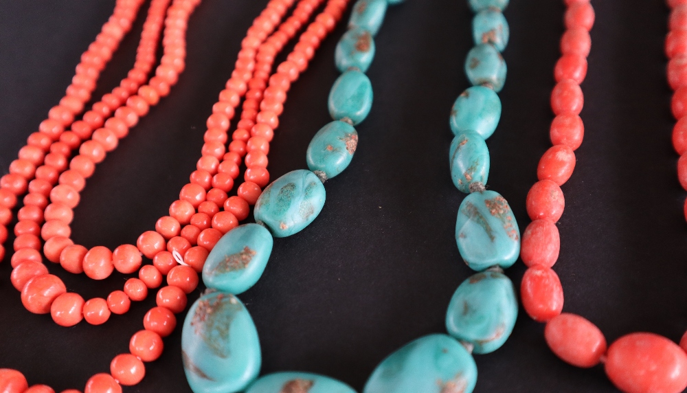 A three strand coral necklace with tapering spherical beads together with another coral necklace