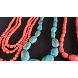 A three strand coral necklace with tapering spherical beads together with another coral necklace