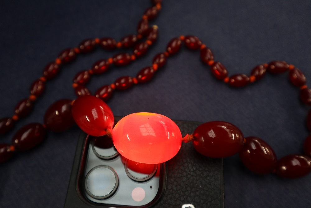 A cherry amber / bakelite beaded necklace, with graduating beads varying in size from 30mm to 10mm, - Image 3 of 9