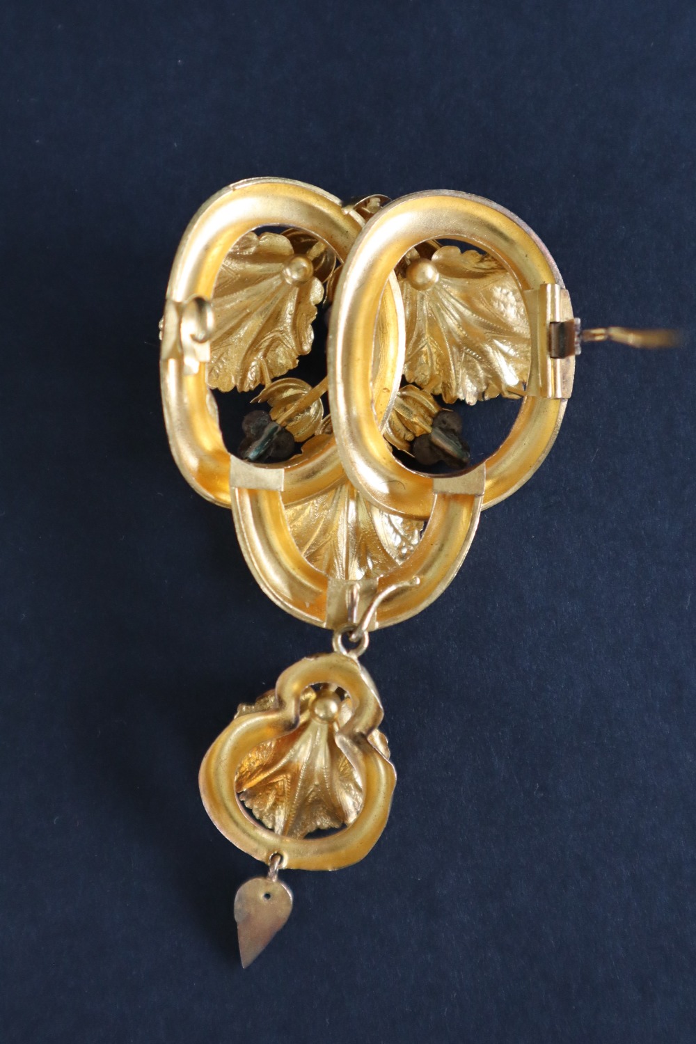 A Victorian yellow metal brooch in the form of three interlaced rings set with vine leaves and - Image 4 of 4