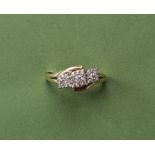A triple cluster diamond ring set with round cut diamonds to a 9ct yellow gold setting and shank,