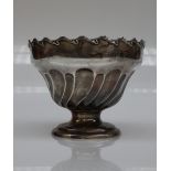 An Edward VII silver pedestal rose bowl, with a wheathusk scrolling border,