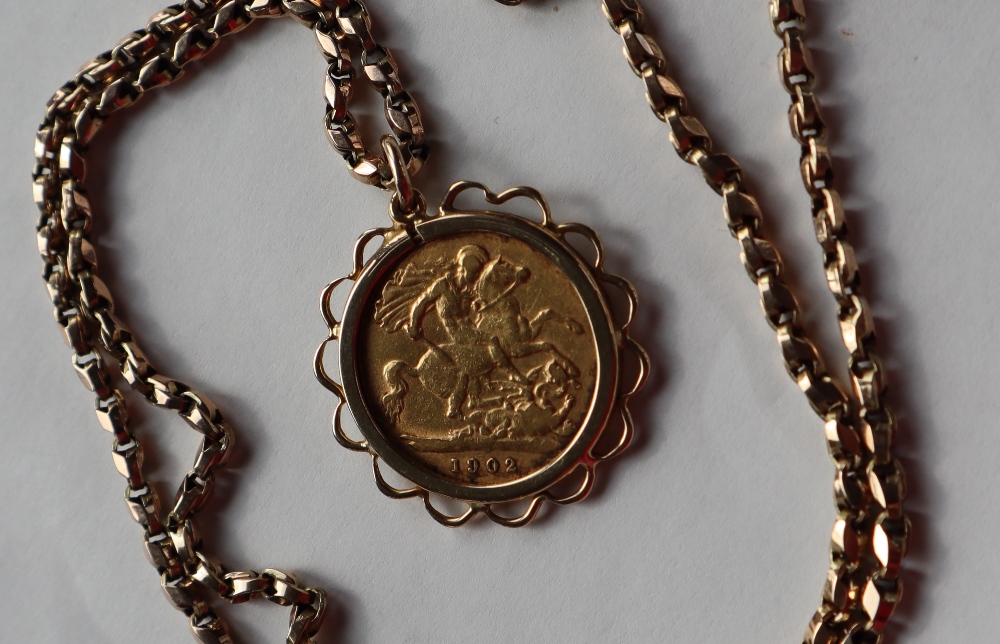 An Edward VII gold half sovereign dated 1902 in a 9ct gold slip mount on a 9ct gold chain,
