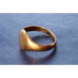 An 18ct yellow gold signet ring with a plain initialled oval shield, size P, approximately 3.