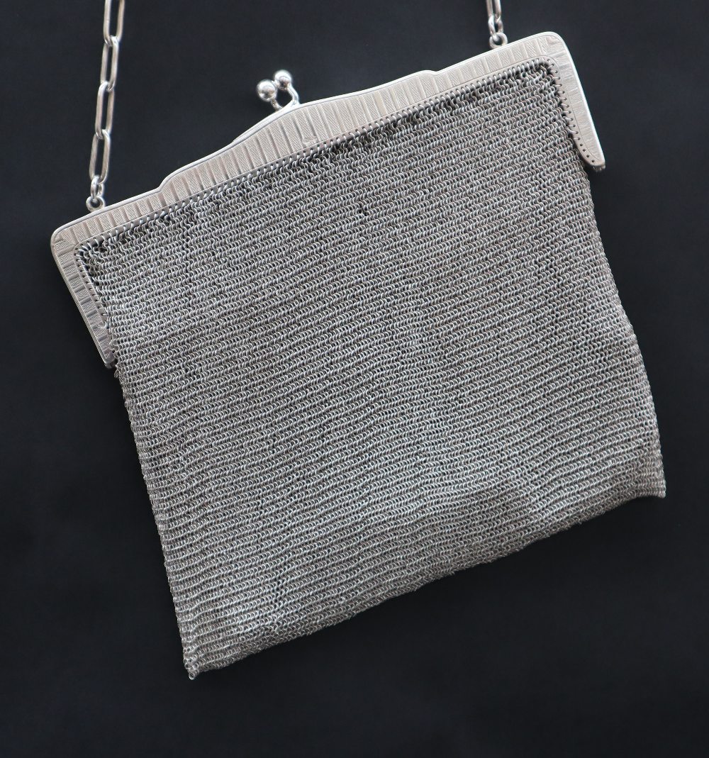 A George V silver mesh purse, with a crossover clasp and chain handle, import marks for London,