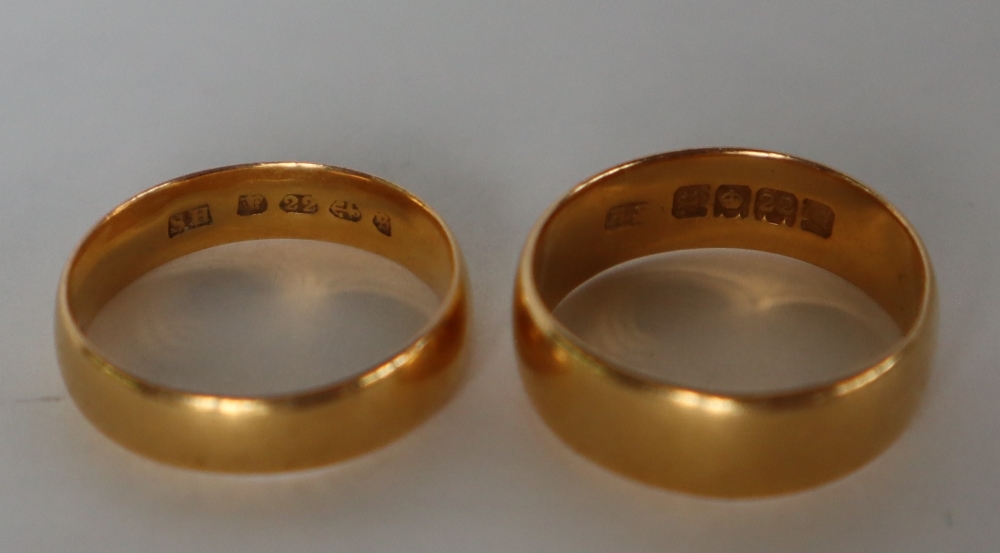 A 22ct yellow gold wedding band, size M, together with another size L, approximately 8.