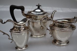 A George V silver three piece tea set, of oval form with swags on a pedestal foot, Birmingham, 1917,