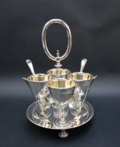 A George V silver egg cup set, comprising four egg cups with gilt interiors,