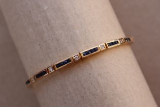 A 14ct yellow gold tennis bracelet set with princess cut sapphires and round brilliant cut diamonds,