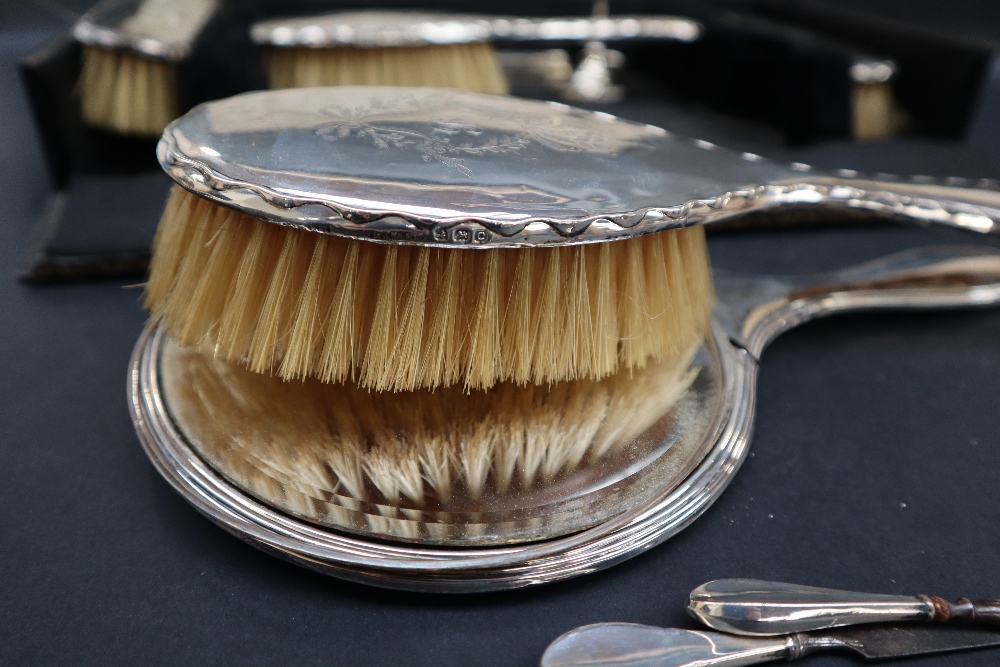 A George V silver backed dressing table set, comprising a hand mirror, a pair of hair brushes, - Image 2 of 2