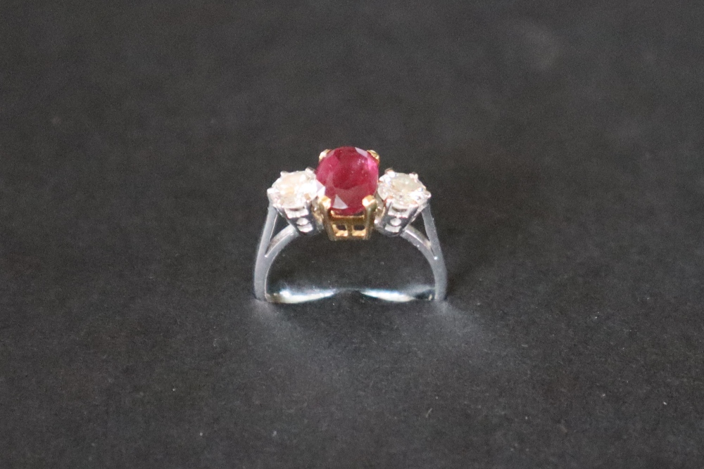 A ruby and diamond ring set with a central oval faceted ruby, approximately 9mm x 6mm, - Image 4 of 12