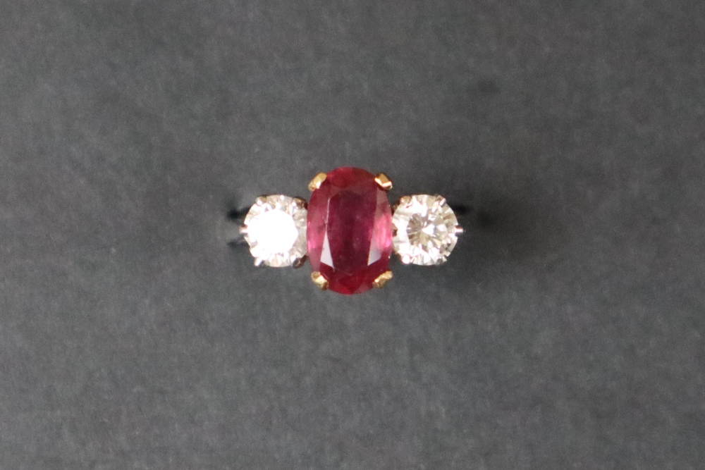 A ruby and diamond ring set with a central oval faceted ruby, approximately 9mm x 6mm, - Image 5 of 12