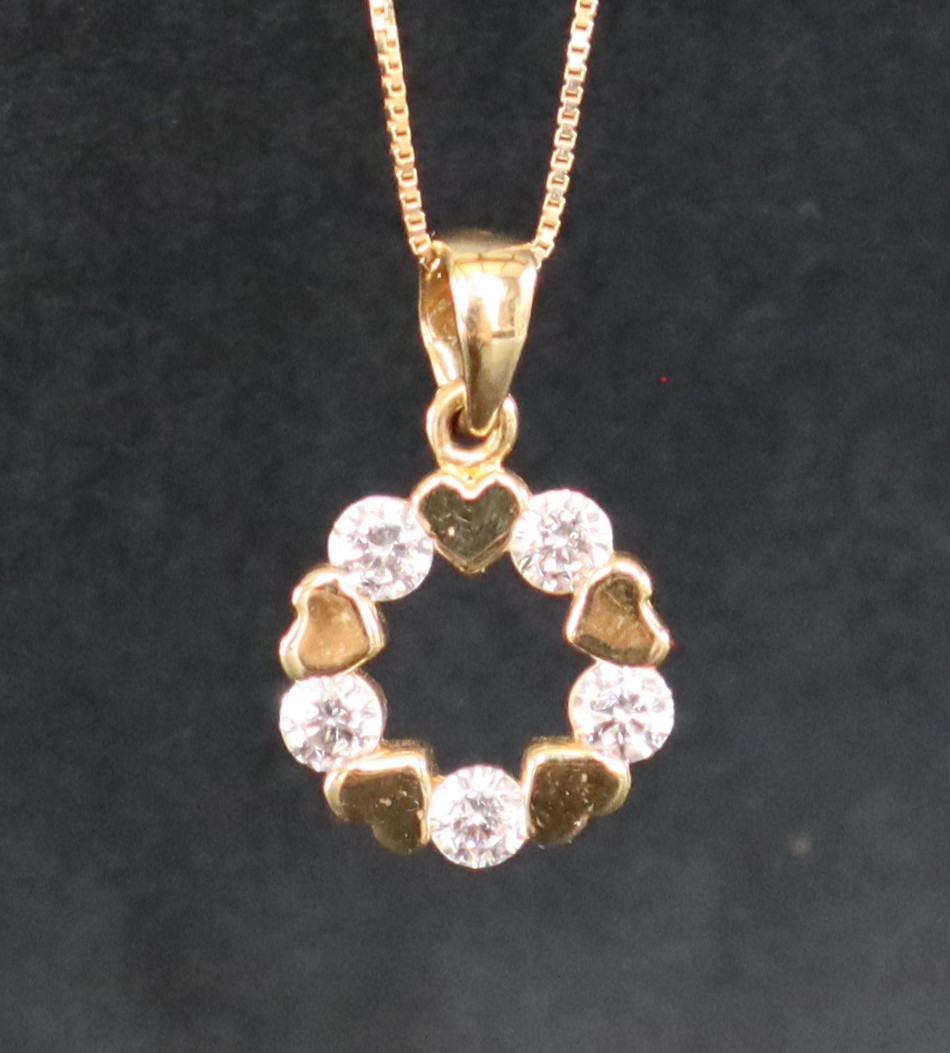 An 18ct yellow gold pendant of circular form, paste set, on an 18ct yellow gold chain,