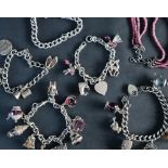 A silver charm bracelet set with numerous charms including a carriage, bird,
