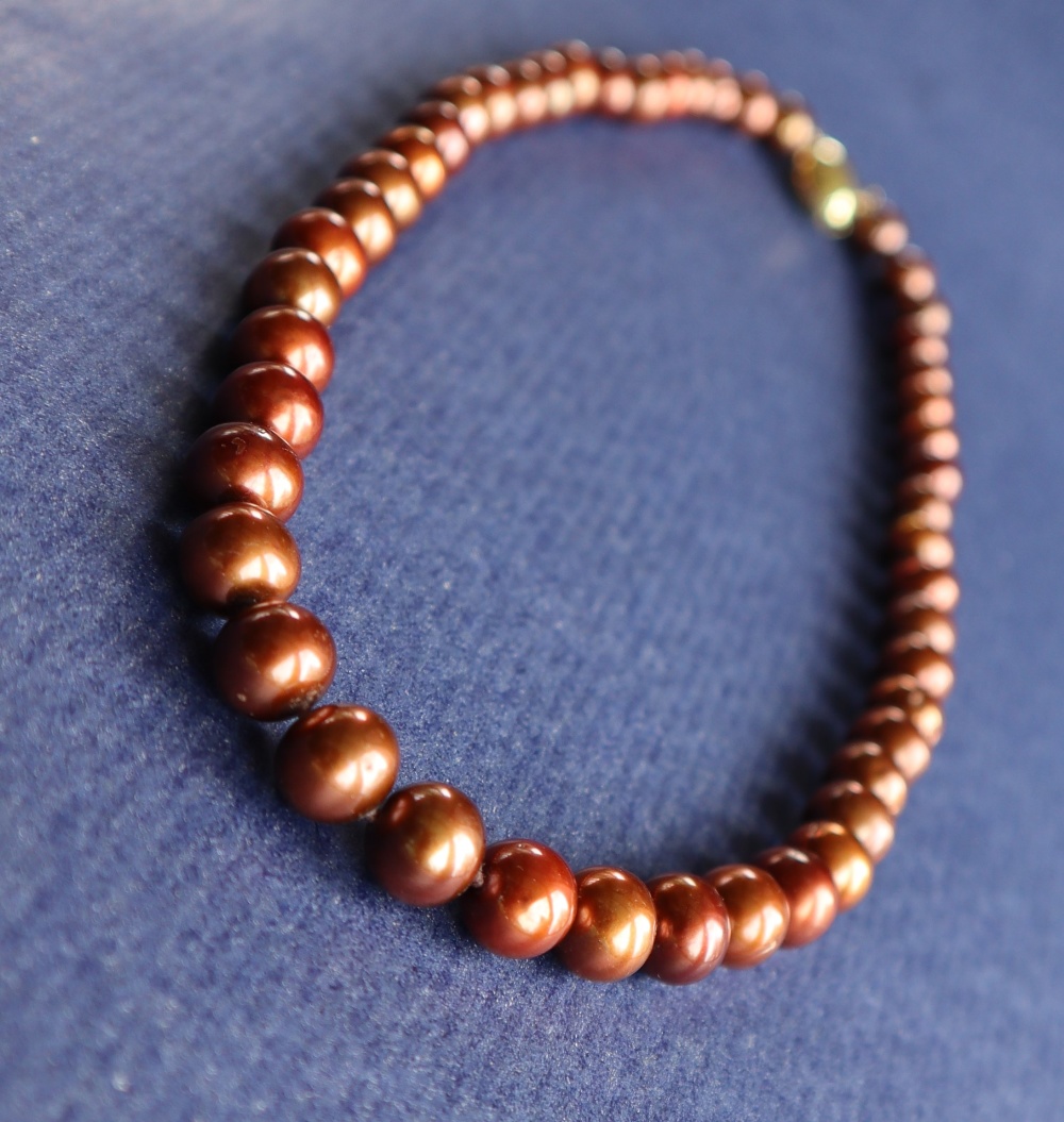 A string of cocoa freshwater cultured pearls, with a 9ct yellow gold "coffee bean" clasp,