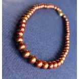 A string of cocoa freshwater cultured pearls, with a 9ct yellow gold "coffee bean" clasp,