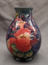A Moorcroft pottery vase decorated with birds and fruit to a royal blue ground,