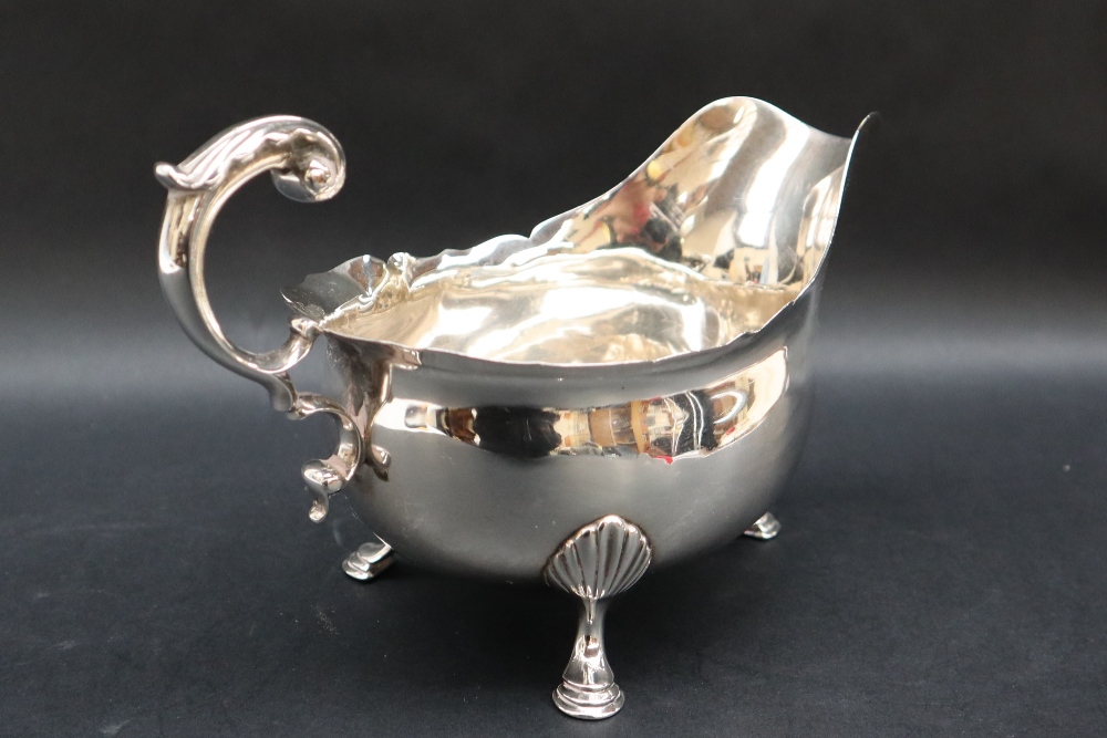 A Victorian silver sauce boat with a flared rim and scrolling handle on three shell capped legs and - Bild 2 aus 4