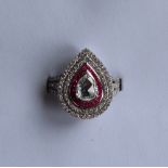 A diamond and ruby dress ring set with a central pear shaped rose cut diamond approximately 0.