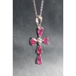 A 9ct white gold pear-shaped ruby and diamond cross on a silver chain