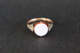 A 9ct gold ring set with a circular hardstone panel to a white metal setting and 9ct yellow gold