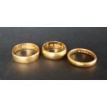 A 22ct yellow gold wedding band, size M 1/2 together with two other 22ct gold wedding bands,