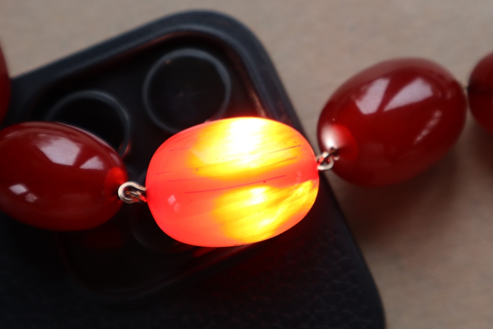 A string of cherry amber / bakelite beads, - Image 7 of 12